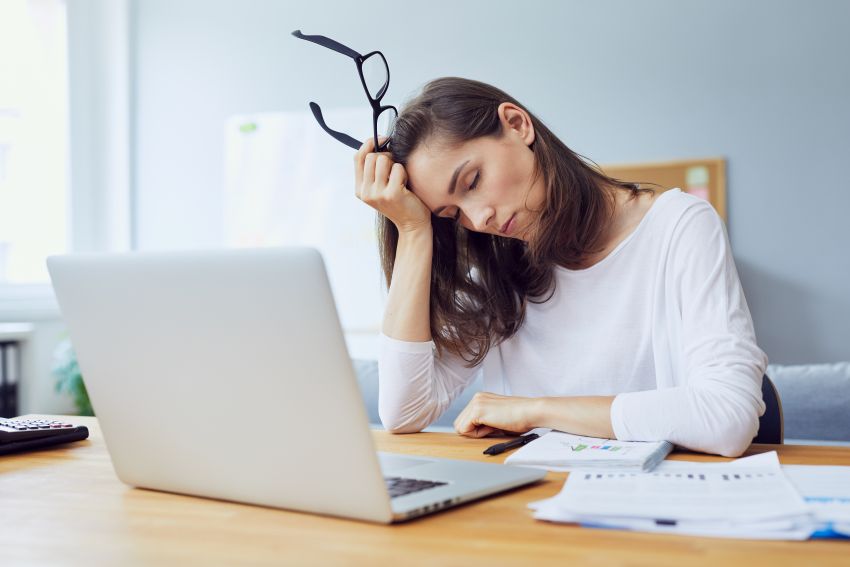 Junge Frau ist müde vor ihrem Laptop