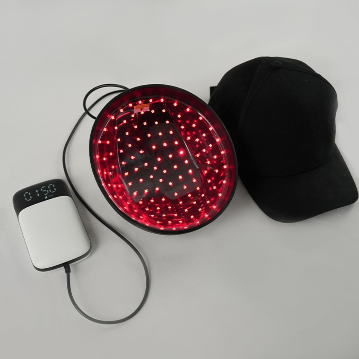 Laser Cap 128 Haarwuchskappe mit Controller und Ladekabel in der Draufsicht